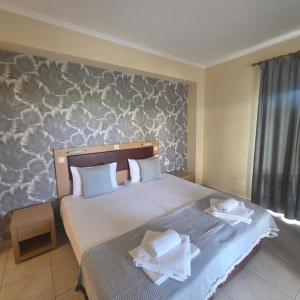 a bedroom with two beds with towels on them at Villa Helga Exotic in Pefkochori