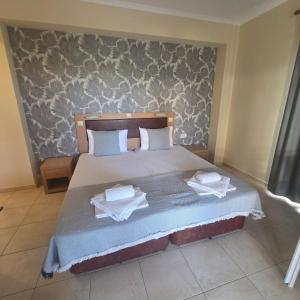 a bedroom with a bed with two towels on it at Villa Helga Exotic in Pefkochori