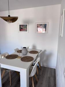 a dining room table with chairs and a white table at Apartamento céntrico de estilo nórdico in Adeje