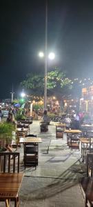 a patio with tables and benches at night at Manancial de Aguas V in Barreirinhas