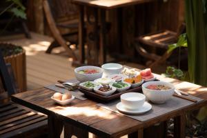 a wooden table with bowls and plates of food on it at Dali Jiwu Hotel in Dali