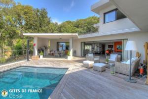 a house with a swimming pool in front of a house at La lunera in Porticcio