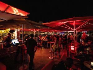 Eine Gruppe von Menschen sitzt nachts in einem Restaurant. in der Unterkunft ibis Styles Lausanne Center MadHouse in Lausanne