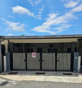 a building with a gate with a pink sign on it at Raub homesty in Raub
