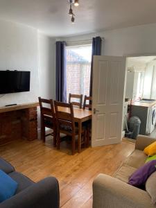 a living room with a table and a dining room at 4 Bedroom House For Corporate Stays in Kettering in Kettering