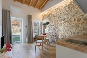 a kitchen with a table and a stone wall at Vila Santa Luzia 4 in Fátima