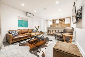 a living room with a couch and a table at 17 Marine - 2 Bedroom - Garden - Apt 104 in Hermanus