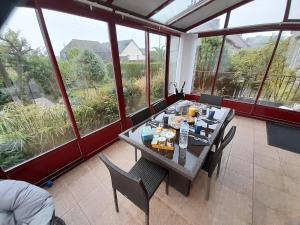 a dining room with a table and chairs and windows at lgbt friendly in Dinan
