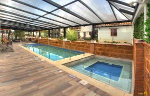 an indoor swimming pool with an open roof with a swimming pool at Hotel Santa Viviana Villa de Leyva in Villa de Leyva