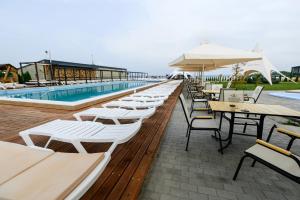 a row of tables and chairs next to a swimming pool at California Resort and SPA in Novoyavorivsk
