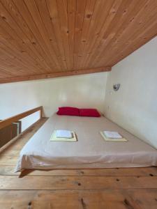a bed in a room with a wooden ceiling at Apartmani Dado in Sutomore
