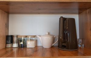 a coffee maker and other items on a wooden shelf at Southlux in Tossor