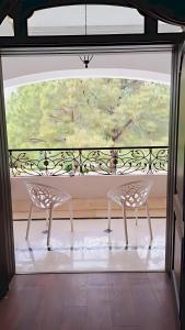 two chairs sitting on a balcony with a large window at Hillside Residence E-7 by Paramount Hospitality in Islamabad