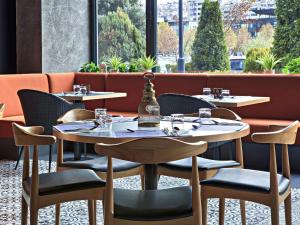 a restaurant with tables and chairs and a window at ibis Styles Sarajevo in Sarajevo
