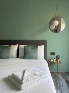 a white bed with a white blanket on top of it at WelcHome Vitorchiano Guest House in Vitorchiano