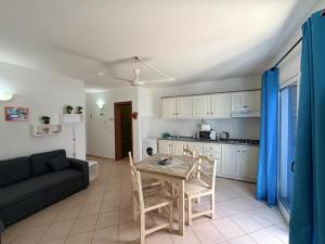 a kitchen and living room with a table and a couch at Top Leme Bedje in Santa Maria