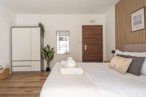 a white bedroom with a large white bed with white towels at Slimiza in Sliema +22 photos