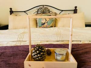 a wooden tray with pine cones on a bed at Hestia by Gunner Lodges in Patriata