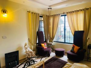 a living room with two chairs and a television at Hestia by Gunner Lodges in Patriata