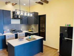 a kitchen with blue cabinets and a white counter top at Hestia by Gunner Lodges in Patriata