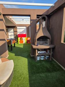 a room with green grass and a play area at Attico Casa ReGa - private parking and bbq in Quartu Sant'Elena