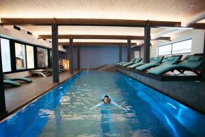 a woman is swimming in a swimming pool at Bio-Berghotel Ifenblick in Balderschwang