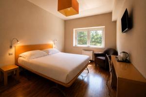 a bedroom with a bed and a desk and a window at San Lorenzo Si Alberga in Camigliatello Silano