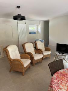 a room with chairs and a tv and a bed at Chambres d'hôtes Les Pratges in Figeac
