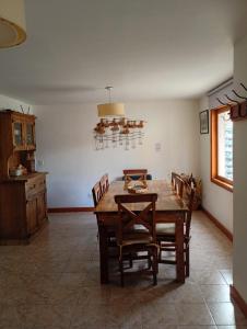 a dining room with a wooden table and chairs at Casas Nahuilen in San Martín de los Andes