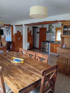 a kitchen and dining room with a wooden table at Casas Nahuilen in San Martín de los Andes +12 photos