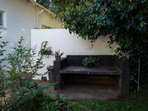 a bench sitting against a wall with potted plants at Leaf & Lark in Bloemfontein
