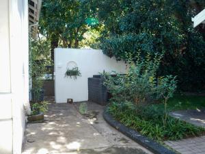 a garden with a white wall and some plants at Leaf & Lark in Bloemfontein