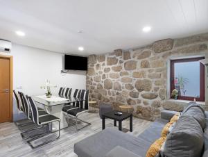 a living room with a table and a stone wall at Quinta do Avô - Casa de Campo in Terras de Bouro