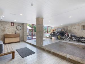 an empty living room with motorcycles and a car in it at Quinta do Avô - Casa de Campo in Terras de Bouro +78 photos