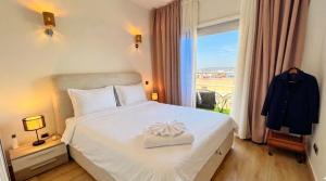 a bedroom with a white bed with a window at Spacious Triplex in Harhoura in El Harhoura +28 photos