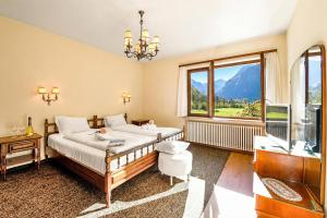 a bedroom with a bed and a television and a window at Casa Mima Chalets in Gerra Verzasca