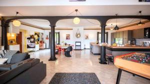 a living room with a pool table and a kitchen at Casa nova in Sagone