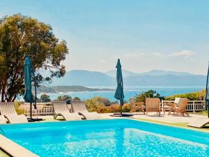a swimming pool with chairs and umbrellas at Casa nova in Sagone