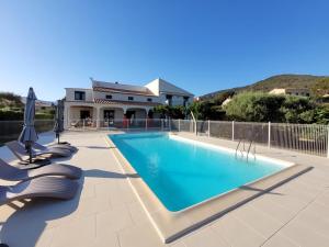 a swimming pool with chairs and a house at Casa nova in Sagone