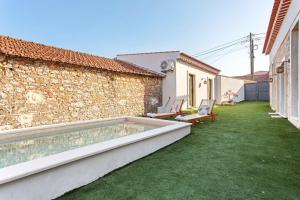 a backyard with a swimming pool and green grass at Vila Santa Luzia 4 in Fátima