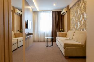 a living room with a couch and a table at Hotel Kragujevac in Kragujevac