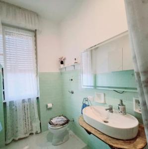 a bathroom with a sink and a toilet at Luino Flowers Home in Luino