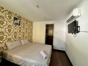 a small bedroom with a bed and a television at Hotel Arba in Kuala Lumpur +17 photos