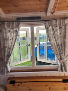 two windows with curtains in a room at Shepherds Rest in Peak Forest