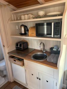 a small kitchen with a sink and a microwave at Shepherds Rest in Peak Forest