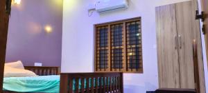 a room with a bed and a window on the wall at NilaTheeram in Trivandrum
