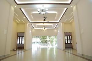 a large hall with a ceiling with a chandelier at NilaTheeram in Trivandrum