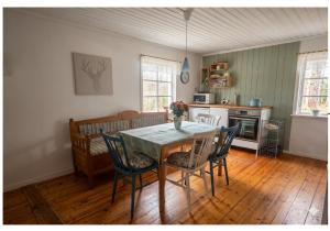 a dining room with a table and chairs and a kitchen at Typisches Schwedisches Haus in Eriksmåla
