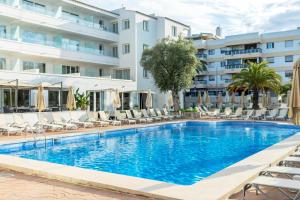 a swimming pool in front of a hotel at THB Dos Playas - Adults Only in Cala Ratjada