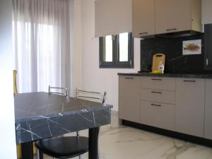 a kitchen with a table and a counter top at Golden Beach Inn in Chrysi Ammoudia